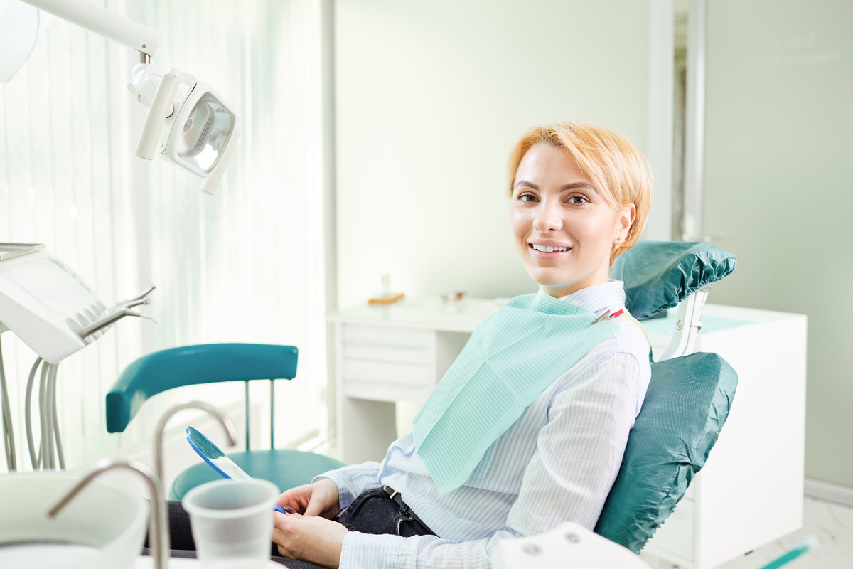 Happy girl patient in the dentist chair.