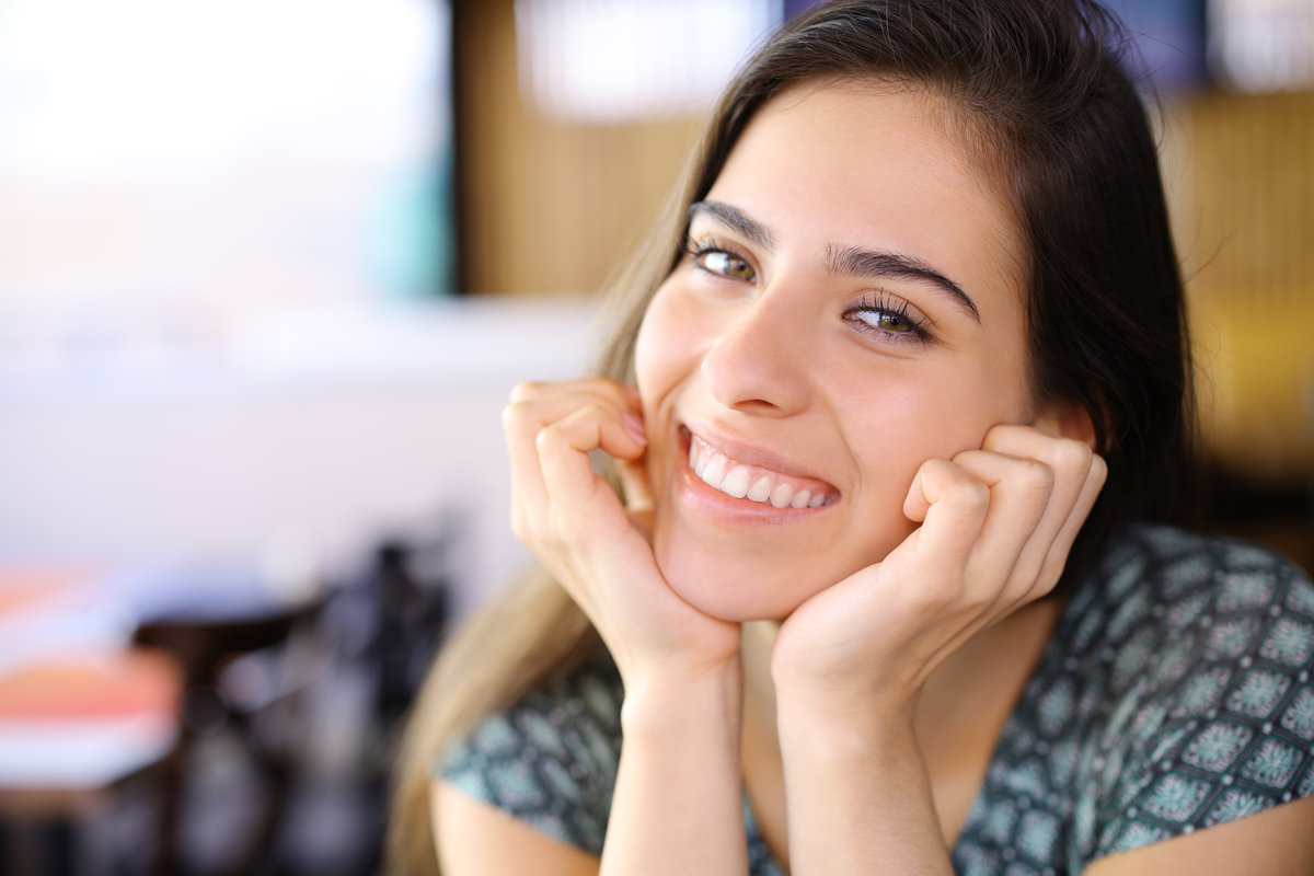 Happy woman with perfect smile looking at camera in a restaurant